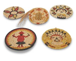 1178 Five Hopi polychrome basketry plaques Mid/late 20th century; Arizona Each Second Mesa coiled plaque with various figural and stylized motifs including a standing Mudhead [Koyemsi], a Palhik Mana motif, a Grandmother [Hahay-i wu-uti] motif, a star or flower motif, and an oval stylized turtle tray with an unfinished edge of tapered grass 5 pieces Largest height 1 1/4 in., diameter 11 in.; smallest height 1 in., diameter 9 in. Estimate: $300 - $500