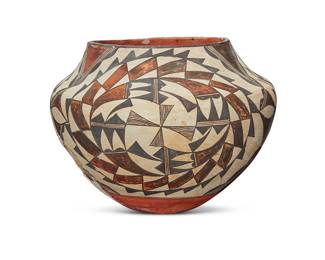 1048 An Acoma Pueblo polychrome pottery jar Mid-20th century With red and black swirling geometric motifs on white slip ground above a puki indentation Unmarked Height 8 3/8 in., diameter 11 1/4 in. Estimate: $300 - $500