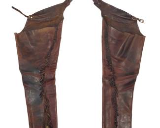 1201 A pair of Western leather chaps Late 20th century The tapered chaps in heavy dark brown leather with a fixed waistband and shaped yoke with contrast stitching, a small silver-tone buckle, and each leg with full length brass zipper closure with short fringing to edges Overall height 35 in. approximately; width 13 1/2 in. at upper leg, 8 in. at ankle Estimate: $200 - $400