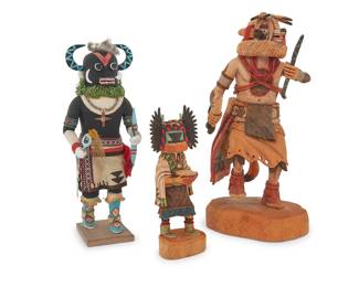 1024 Three Southwest polychrome katsina carvings Late 20th/21st century Comprising three Hopi style carved wood katsina figures including a 'Crow Mother' by Kevin Sekakuku (b. 1977, Hopi) and a larger Wolf katsina with dance stick and rattle, as well as a 'Ho-o-te' or 'Ahote' katsina dancer with a horned mask with moon and star motifs, and with feather and fur accents One signed and titled to base; one titled to base 3 pieces Largest height 12 3/4 in., width 6 in., depth 6 1/2 in.; smallest height 7 3/4 in., width 3 in., depth 2 1/2 in. Estimate: $600 - $900