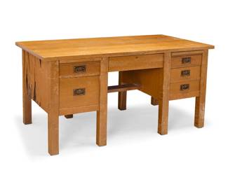 1193 A Gustav Stickley oak desk, model 711 1907-1912; Eastwood, NY The oak desk with rectangular top over a central lockable drawer flanked by two writing slides above a series of drawers with hammered copper pulls, raised on eight straight legs Stamped with Craftsman shop mark [joiner's compass] and paper label Height 30 in., width 60 1/4 in., depth 32 in. Estimate: $1,200 - $1,800