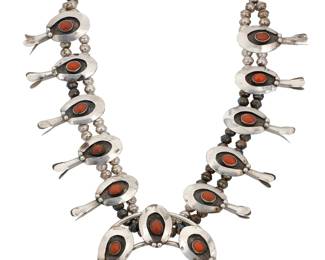1378 A Southwest sterling silver and coral squash blossom necklace Mid-20th century Comprising ten shadow-set coral blossoms with a central naja with five matching shadow-set plaques, all on a double strand of silver beads Unmarked 21 1/2 x 3 in. 124 grams gross Estimate: $600 - $800