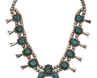 1377 A Southwest sterling silver and turquoise squash blossom necklace Late 20th century A double strand necklace with ten set turquoise blossoms, suspending a matching set turquoise silver naja, all with applied silver wire and stamped accents Stamped: A [conjoined with line above] / CS [possibly Cecil Sanders, Diné] 23 x 2 1/2 in. 125.7 grams gross Estimate: $700 - $900