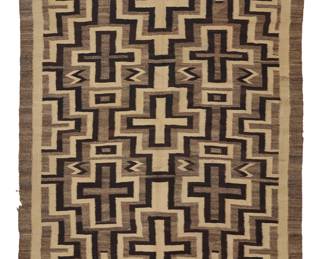 1224 A Diné (Navajo) regional rug First half 20th century Woven in natural cream, brown, and mottled brown wool featuring three columns of interlocking stacked concentric crosses with floating zigzags and partial stepped diamonds to the sides 7 ft. x 4 ft. 9 in. approximately Estimate: $800 - $1,200