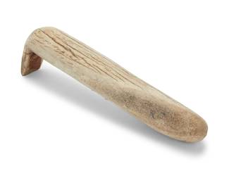 1113 An elk horn hide scraper 20th century The long cylindrical antler scraper with carved scraper 'foot' to one end Height 11 3/4 in., width 2 in., depth 3 1/2 in. approximately Estimate: $100 - $200