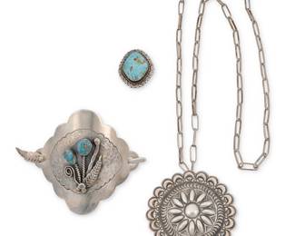 1396 Four Southwest silver jewelry items Mid/late 20th century Comprising a large hammered silver hair slide with fine line incised texture to center and a stylized floral motif of set turquoise and applied silver feather and wire accents, with a matching stick by Roy Vandever (1936-2009, Diné [Navajo]), together with a sterling silver repoussé concho pendant/brooch with stampwork by Tommie Charlie (b. 1952, Diné [Navajo]), together with a handmade paper clip chain, and a sterling silver and set turquoise ring Variously stamped for artist: Tc / Roy Vandever [etched signature] / NRB; one stamped for sterling 4 pieces Hair slide 3 x 4 in., stick 4 in.; pendant/brooch diameter 2 5/8 in., chain 30 1/4 in.; ring size 7 109.7 grams gross Estimate: $200 - $400