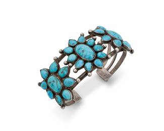 1371 A Diné (Navajo) or Zuni sterling silver and turquoise cuff bracelet First half 20th century A chunky three-wire cuff with three cluster-set floral style turquoise plaques and silver ball accents Unmarked 7 3/4 in. total inner C x 1 5/8 in., including a 1 1/4 in. gap 83.1 grams gross Estimate: $1,200 - $1,800