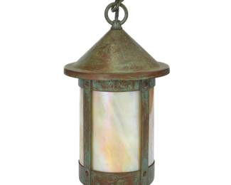 1312 An Arroyo Craftsman Arts & Crafts-style cylindrical lantern Early 21st century The patinated brass case with iridescent slag glass panels housing a single light, electrified Factory label applied to escutcheon interior Height overall 20 in.; height of lantern 12 1/2 in., diameter 6 7/8 in. Estimate: $200 - $300