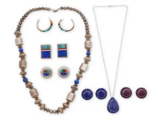 1405 Seven Southwest silver jewelry items Late 20th/21st century Comprising a chunky silver necklace featuring blue lapis lazuli beads and large sterling silver barrel beads, and a lapis lazuli inlay teardrop pendant on an associated chain, as well as five pairs of stone inlay earrings including a pair of Sunface motif earrings in coral, malachite and lapis lazuli inlay by Chester Benally (Diné [Navajo]), a pair of lapis, coral and turquoise inlay earrings by John Shopteese (Pottawatomi), a pair of multistone geometric inlay half-hoops, and two round pairs with lapis and with purple stone inlay 12 pieces Three marked for artist: C. Benally / J [with fish picto] / E; two marked for Sterling 12 pieces Necklaces 27 in. & 22 x 1 3/8 in.; earrings 1 3/8 in. to 1 in. 172.4 grams gross Estimate: $200 - $400
