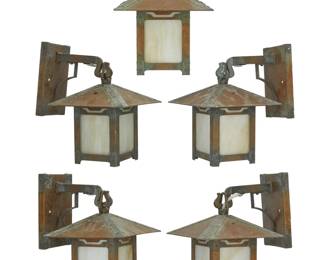 1317 A set of five Old California Lantern Co. Arts & Crafts-style lanterns 2004 The patinated brass cases with slag glass panels housing a single light, each hanging from arm issued from wall-mounted escutcheon, electrified Each with factory metal label applied to escutcheon; each dated to applied paper label and with model number: #1-182 5 pieces Height of lanterns only 10 in., width 8 1/8 in., depth 8 1/8 in.; height overall 12 in., depth from wall 10 in. Estimate: $300 - $500
