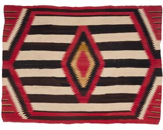 1215 A Diné (Navajo) third phase blanket-style weaving First half 20th century Woven in red, cream, brown, and ochre wool with contrast banding and a sawtooth diamond to center, with hatched lines to each corner 6 ft. x 4 ft. 5 in. approximately Estimate: $2,000 - $3,000