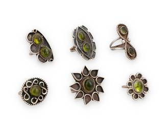 1383 Six Southwest-style sterling silver and gemstone rings Mid-20th century A group of sterling silver rings each with set peridot cabochons and silver wire overlay, in various stylized floral and curvilinear shapes Four variously stamped: S K [larger] / M [possibly for Melissa Yazzie, Diné] 6 pieces Ring sizes 8 1/4 to 6 46.9 grams gross Estimate: $200 - $400