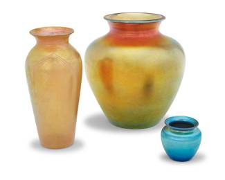 1261 Three American iridescent glass vases 1920s Three works:  A Steuben 'Aurene' vase Etched: STEUBEN / AURENE / 268 [indistinct] Height 8 3/8 in., diameter 7 5/8 in.  A Kew Blas pulled feather iridescent glass vase Etched to underside: KEW-BLAS Height 8 1/8 in., diameter 3 7/8 in.  A diminutive iridescent blue glass vase Unmarked Height 2 5/8 in., diameter 2 3/4 in.  3 pieces Estimate: $400 - $600