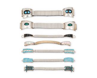1413 Seven Southwest silver and set stone watch bands Late 20th century Comprising seven silver and set stone two-piece watch band end sets, in various styles including shadowbox set turquoise and malachite, needlepoint turquoise, turquoise and mother of pearl row-set inlay, and mother of pearl and onyx channel inlay, each set attached to an associated stretch metal band Variously marked for artist: CL / A & G Tucson [etched script] / P; one marked for sterling 7 pieces Largest set each 1 1/8 x 1 3/4 in.; smallest set each 1/2 x 1 1/8 in. 112.0 grams gross Estimate: $300 - $500
