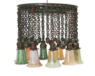 1101 A 'Moorish' chandelier in the style of Tiffany Studios Early and later 20th century elements Some shades marked: quezal Verdigris patinated bronze issuing ten lights, each with various pulled feather glass Quezal-style shade, each light alternating with three ball-and-chain elements, electrified Height 19 1/4 in., diameter 25 in.; escutcheon diameter 20 1/2 in.; height of shades 5 in., approx. Estimate: $1,000 - $1,500