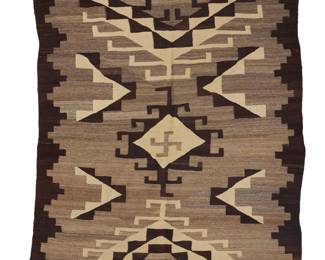 1225 A Diné (Navajo) regional rug First half 20th century Woven in variegated brown, grey, dark brown, and cream wool with a central hooked diamond with a whirling log motif, two elaborate stepped hooked triangles, flanked by floating stepped motifs, all within a stepped dark brown border 7 ft x 5 ft 4 in. Estimate: $700 - $900