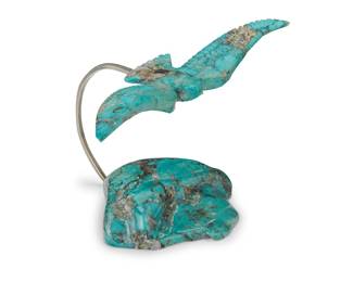 1418 Wayne Paquin (1951-2008, Zuni/Jicarilla Apache) A carved turquoise eagle fetish sculpture, late 20th century With a carved eagle in flight suspended from a sterling silver wire arch attached to a carved turquoise boulder, with a sterling plaque to front Signed to plaque on base: Wayne Paquin / Zuni Height 3 3/4 in., width 5 1/2 in., depth 4 1/8 in. Estimate: $200 - $400