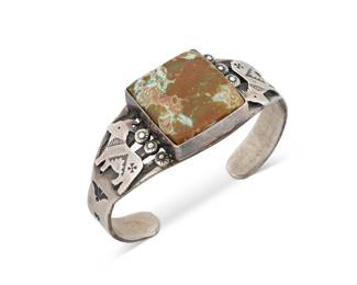 1351 Albert Payton (20th/21st century, Diné [Navajo]) A chunky sterling silver pictorial cuff with central large square set turquoise and with silver overlay goats and stampwork including whirling log motifs Stamped: A. Payton [script] / Sterling 6 3/4 in. total inner C x 1 in., including a 1 1/8 in. gap 57.1 grams gross Estimate: $500 - $700