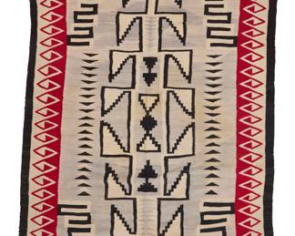 1281 A large Diné (Navajo) regional rug Second half 20th century Woven in brown, cream, red, and pale grey wool with a central elongated stepped hooked diamond with floating stepped elements within and flanked by contrast meanders to each corner, stacked triangles to the center all within a complex hooked border and banding to all edges 9 ft. x 5 ft. approximately Estimate: $800 - $1,200