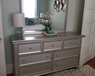 Silvery dresser matches end tables; table lamp; area rug