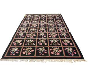 Dark traditional rug with repeating floral panels and a detailed decorative border.