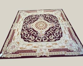 Ivory and burgundy rug with a dramatic central medallion and ornate border.