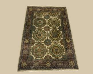 Deep green rug with repeating gold circular motifs and traditional detailing.