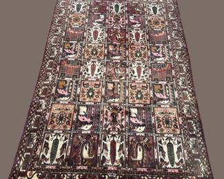 Dark traditional rug with intricate repeating motifs and a detailed border.