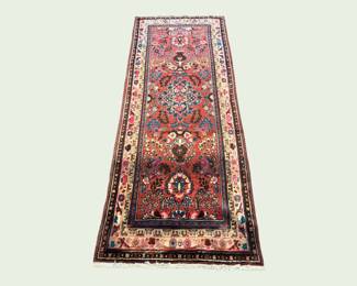 Narrow red runner with intricate traditional motifs and a detailed border.