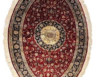 Round red and ivory rug with an elaborate circular medallion and ornate border.