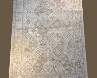 Pale neutral rug with subtle geometric patterning and a softly distressed finish.
