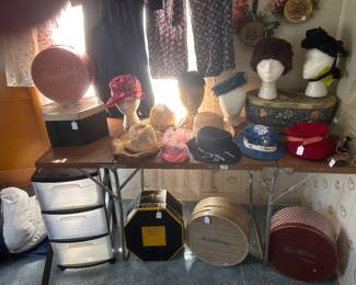 A selection of vintage clothing and vintage hats and hat boxes.