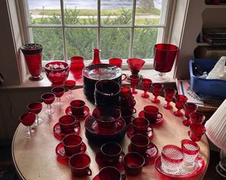 a variety of red and ruby red dishes/stemware