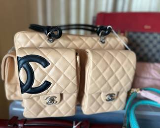 Chanel Cambon Ligne multi-pocket reporter bag in beige quilted leather with black CC logo and knotted shoulder straps.