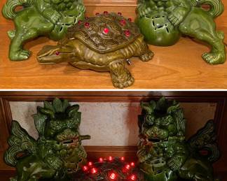 a pair of green glazed ceramic Foo Dog (guardian lion) statues and a vintage turtle figurine that lights up.