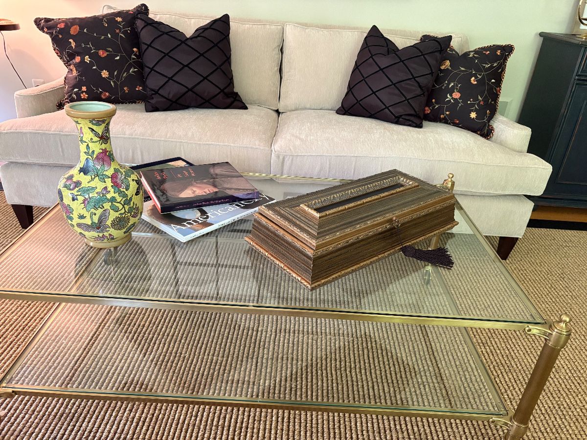 Ivory 2-cushion couch (matched set of 2 available) shown with champagne brass coffee table on casters over sisal rug trimmed in black leather