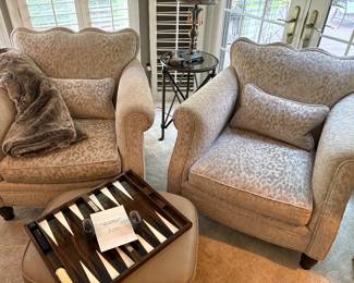 Matched set of gray leopard print armchairs and shown with leather ottoman, iron and metal side table and backgammon board
