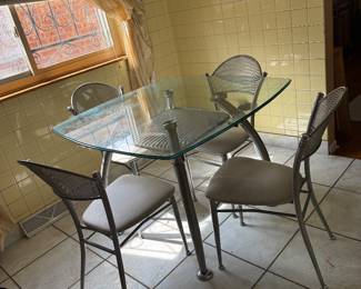 Modern 5 piece glass-top dining set with metal frames and matching upholstered chairs