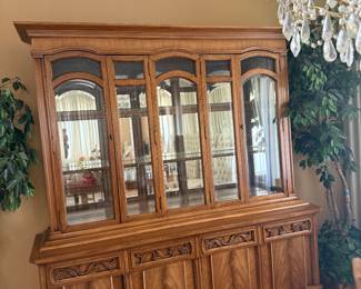 Vintage two -piece lighted oak china cabinet and buffet hutch featuring arched glass upper doors and lower storage cabinets