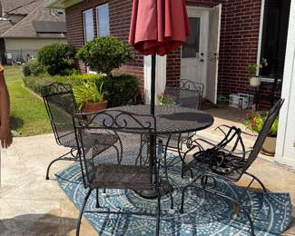 Wrought Iron Dining Set with Umbrella with rocking chairs.