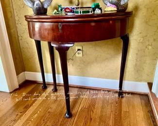 Queen Anne style mahogany Demi-lune card table. Folds open from a half-round console to a full circular games table. Cabriole legs with pad feet.