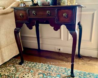 Queen Anne style oak lowboy with three drawers, shaped apron, and cabriole legs.