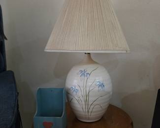 ceramic table lamp with a white/cream ribbed pottery body and hand-painted blue iris/floral decoration