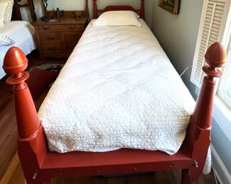 Twin bed with red headboard and footboard