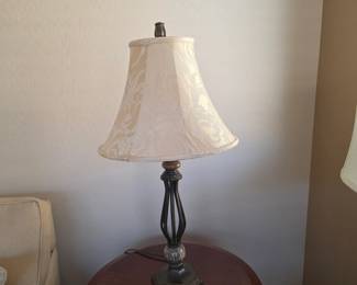 Traditional table lamp with ornate metal base and cream floral shade.