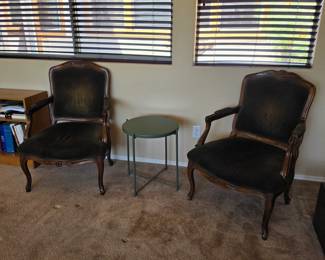 vintage French-style carved wood armchair featuring dark upholstered seating and ornate wooden scrollwork on the armrests