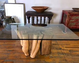 One of two glass top tree root base tables