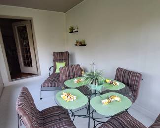 Wrought iron patio set with glass table and weather resistant accessories