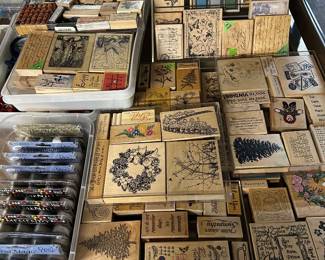 A large collection of assorted wood-mounted rubber stamps, ink pads…