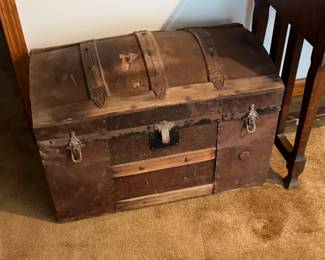 Antique dome-top steamer trunk or camel-back or humpback trunk), which typically dates from the late 19th century (circa 1870–1890s).